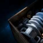 transit damage - Korpack - Packaging Solutions for Complex Businesses Crate containing a cracked large glass light bulb with its metal base, surrounded by packing material.