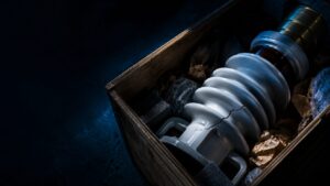 transit damage - Korpack - Packaging Solutions for Complex Businesses Crate containing a cracked large glass light bulb with its metal base, surrounded by packing material.